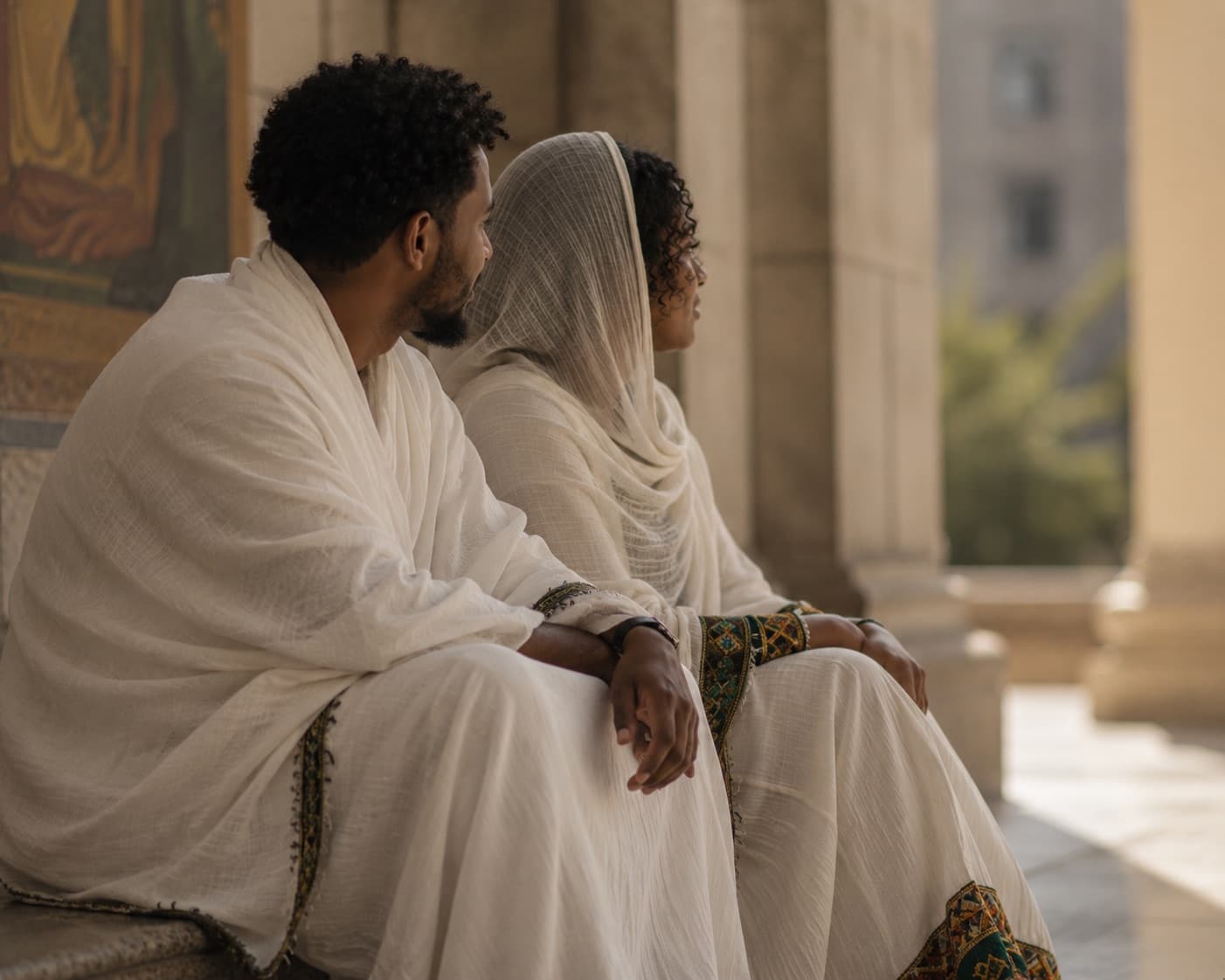 A Habesha woman in a netela beside an Orthodox church colonnade